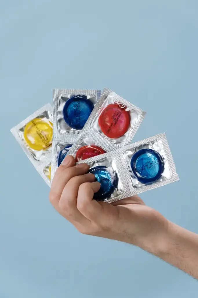 mand holder farvede kondomer